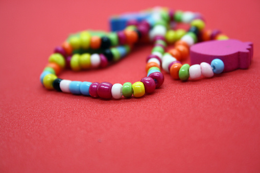 A bracelet made of beads on a red background. Space for text.