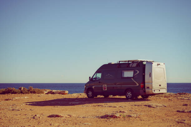 istock Camper van on sea cliff, camping. 1311398947