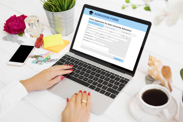 Person submitting admission form on laptop computer