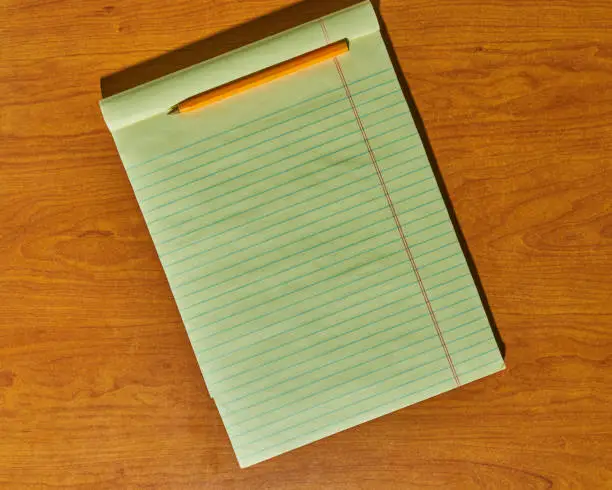 Yellow notepad on a wooden background