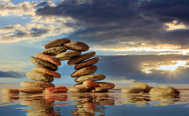 istock Zen stones bridge stack on cloudy sky and sea background. 1311401346