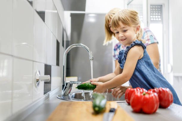 istock Kid washing vegetables and smiling 1311402585