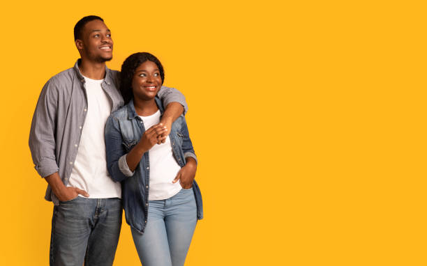 istock Young happy black couple embracing and looking at copy space with interest 1311404930