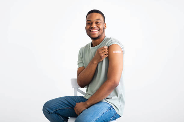 istock Happy Black Man Showing Vaccinated Arm With Plaster, White Background 1311404937