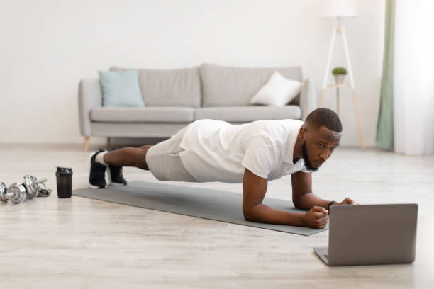 istock African Guy Exercising Standing In Plank At Laptop At Home 1311404964