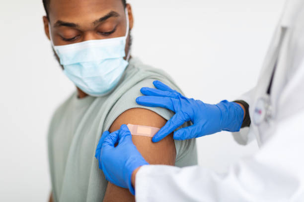 istock Man Getting Vaccinated Against Covid-19, Doctor Applying Plaster, White Background 1311405228