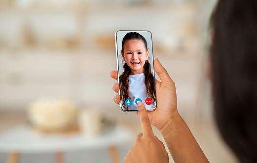 Mother talking to her daughter via video call on smartphone. Mom teleconferencing with her child, enjoying modern technologies for communication, creative collage, closeup