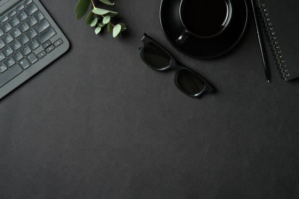 istock Top view creative workspace with laptop computer, cop of coffee, glasses and supplies on black leather background. Flat lay, view from above. 1311406366