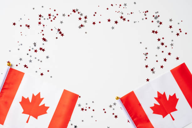 istock Happy Canada Day banner mockup. Canadian flags and confetti on white table. Flat lay, top view, copy space. 1311406507