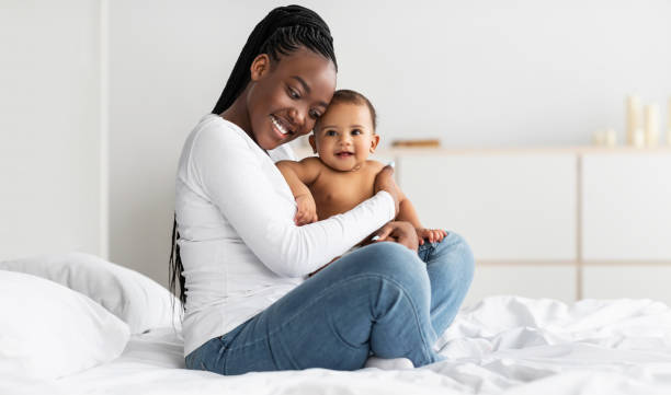 istock Black mom sitting on bed with her cute baby 1311406523