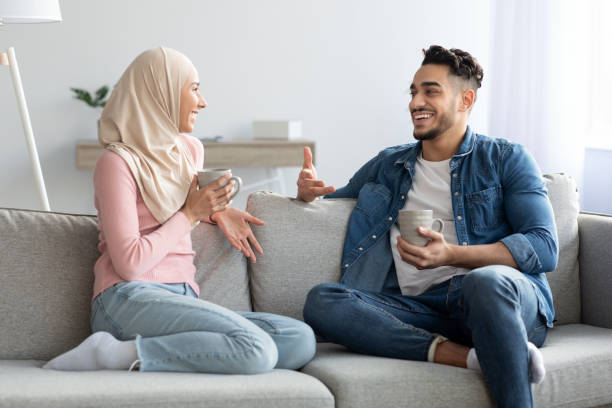 istock Young muslim couple drinking tea and talking at home 1311407605