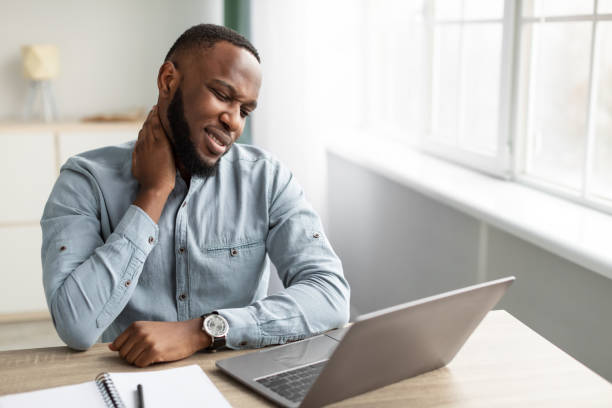 istock African Man Massaging Neck Suffering From Pain Sitting At Workplace 1311407684