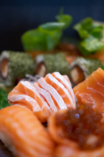 istock Sashimi set containing salmon rolls, salmon sashimi decorated with vegetable on cold ice. Selective focus 1311408722