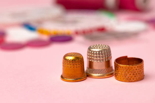 iron thimbles for sewing on pink background - thimble sewing item close up studio shot imagens e fotografias de stock
