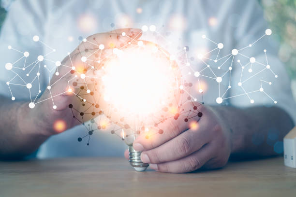 istock Man in white shirt holding light bulb with start up and icon network connection on modern virtual interface. Concept of New idea. Creativity and inspiration. Digital marketing. 1311408941