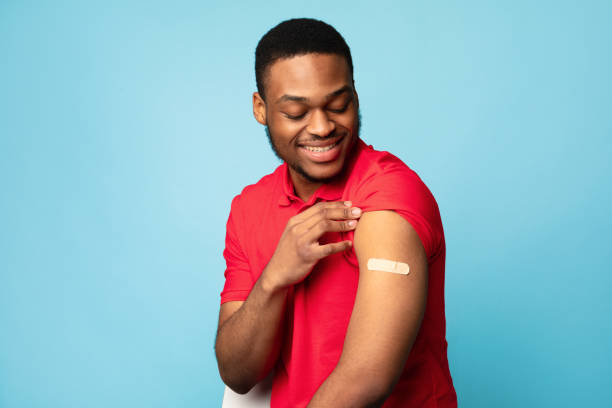 istock Covid-19 Vaccinated African Guy Showing Arm After Injection, Blue Background 1311409027
