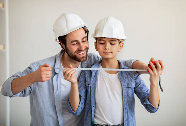 papà felice e suo figlio che fanno misurazioni usando la roulette, papà insegnante ragazzo per il lavoro di costruzione - little boys measuring expressing positivity intelligence foto e immagini stock