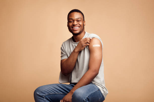 istock Covid-19 Vaccinated African Man Showing Arm With Plaster, Beige Background 1311409222