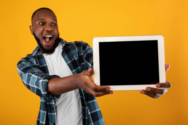 istock African Guy Showing Digital Tablet With Blank Screen In Studio 1311410405