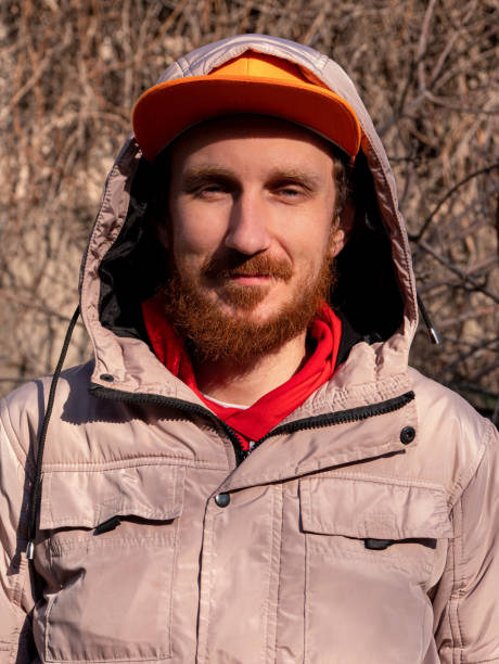 istock Bearded hipster guy millennial in orange snapback on nature background on spring sunny day. Funny red beard male face 1311410673