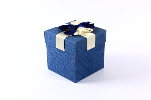 Christmas or birthday gift box on white wooden table against blue turquoise bokeh lights. Holiday greeting card concept.