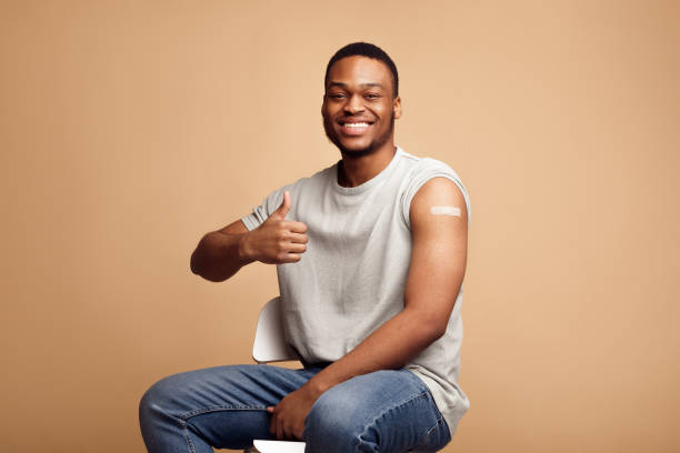 istock Vaccinated African Guy Gesturing Thumbs-Up After Covid-19 Vaccine Injection, Studio 1311410901