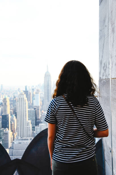 istock Girl Looking At Manhattan Skyline From Rooftop 1311411050