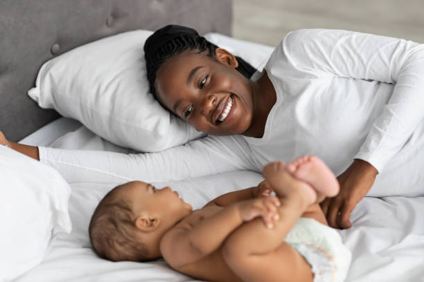 istock Happy black mom lying in bed with her cute infant 1311411162