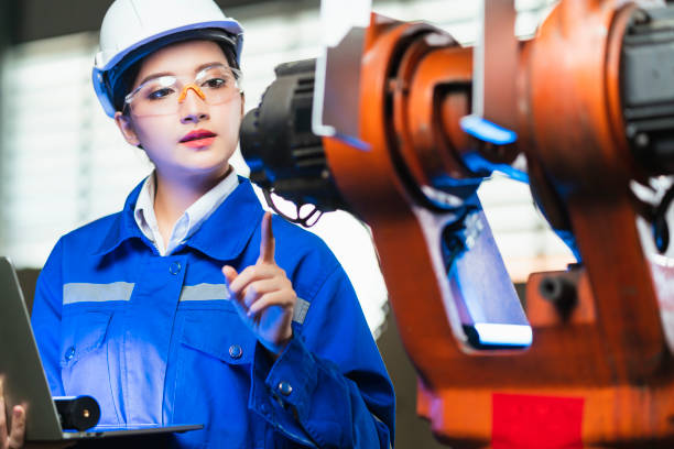 istock engineer specialist asian female and  technician maintenance inspect relay robot arm system with laptop  to control quality operate process work heavy industry 4.0 manufacturing smart factory 1311412815