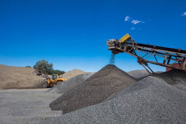 Open-pit mine Conveyor belt, an excavator and a pile of gravel. Open-pit mining. No people. gravel mound stock pictures, royalty-free photos & images