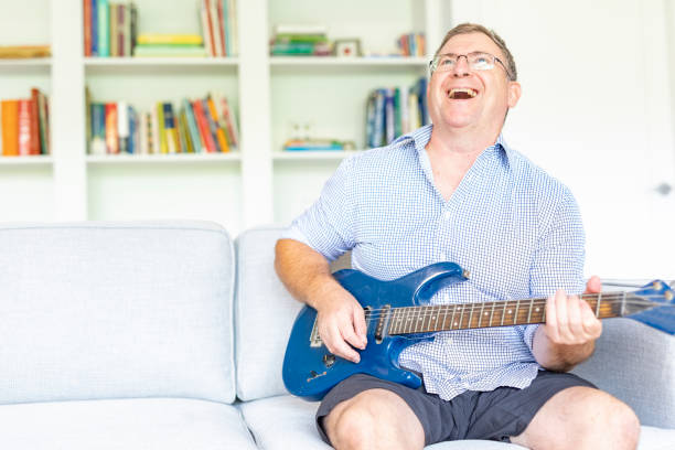 istock Middle Aged Man Having Fun Playing a Guitar at Home 1311414511
