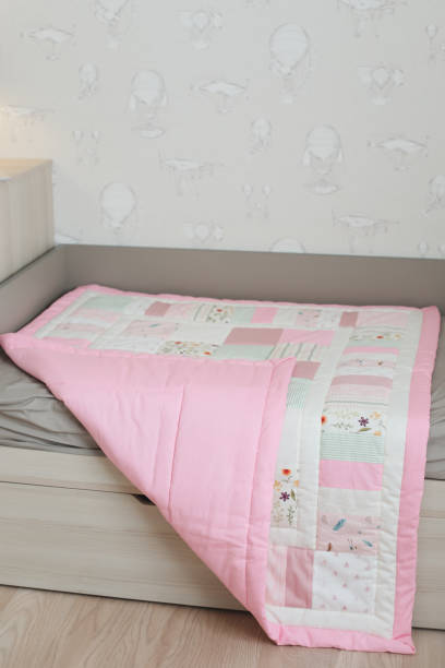 istock Cozy baby cot with pink patchwork blanket. Baby bedding. Bedding and textile for nursery. Nap and sleep time 1311414590