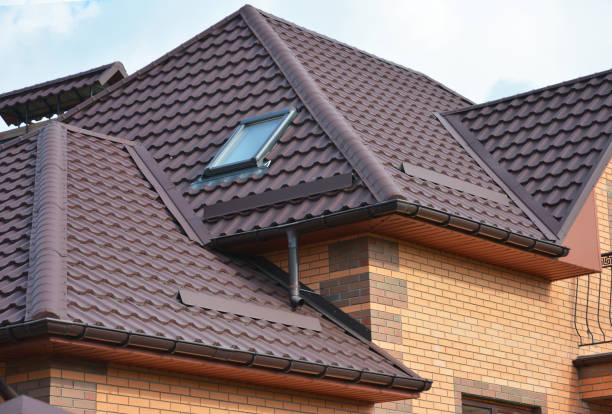 istock Complex roof design, metal tiled expensive roofing construction with a skylight, snow guards, chimney of a brick house. 1311414797