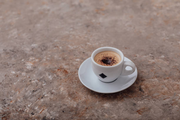 istock Single cup of coffee with cream and chocolate chips on a beautiful textured gray background with orange streaks 1311414853