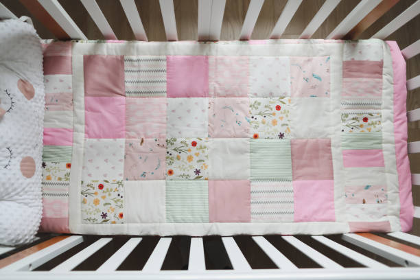 istock Cozy baby cot with pink patchwork blanket. Baby bedding. Bedding and textile for nursery. Nap and sleep time 1311414861