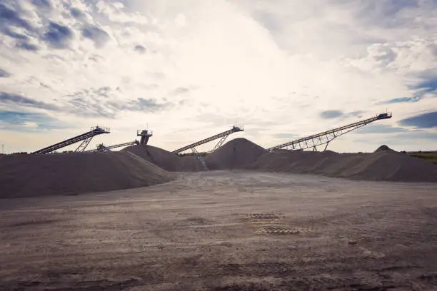 Conveyor belts in open-pit mine at sunset. No people.