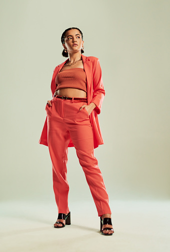 Studio shot of a fashionable young woman posing against a green background