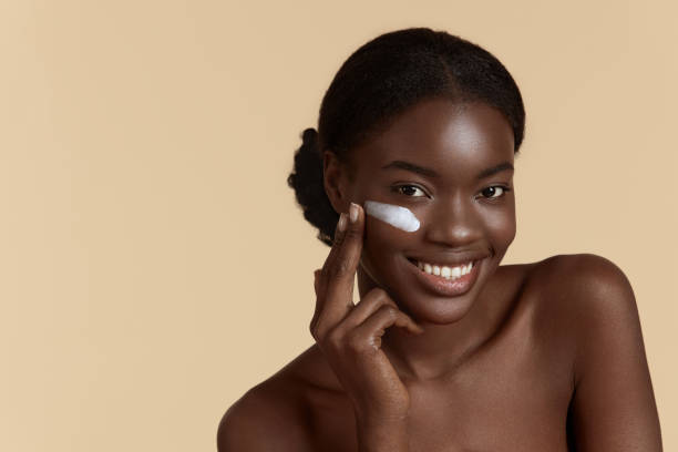 istock Black girl apply cosmetic cream on face 1311418901