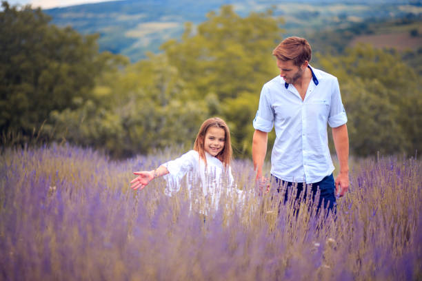 istock Father and daughter walking trough lavender field. 1311419942