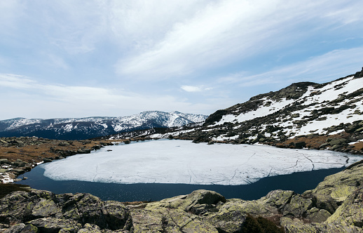 Frozen lake in the top of snowy mountains. Peñalara peak madrid. Winter lanscape