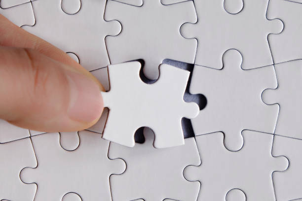 istock Man placing last piece on to jigsaw puzzle 1311420360