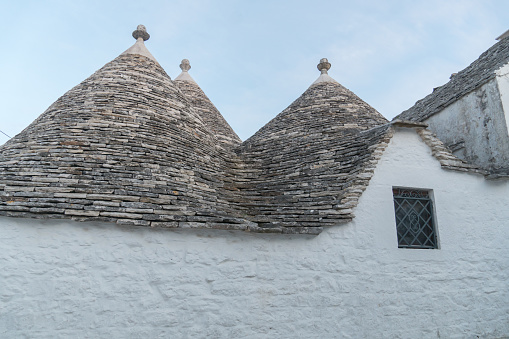 Trullo constructions in the city of Alberobello.  A trullo is a traditional Apulian dry stone hut with a conical roof. Their style of construction is specific to the region of Apulia, south of Italy.