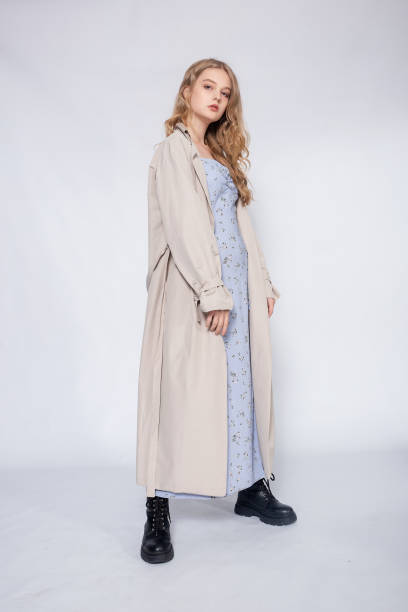istock beautiful girl in beige raincoat posing in Studio on grey background 1311425432