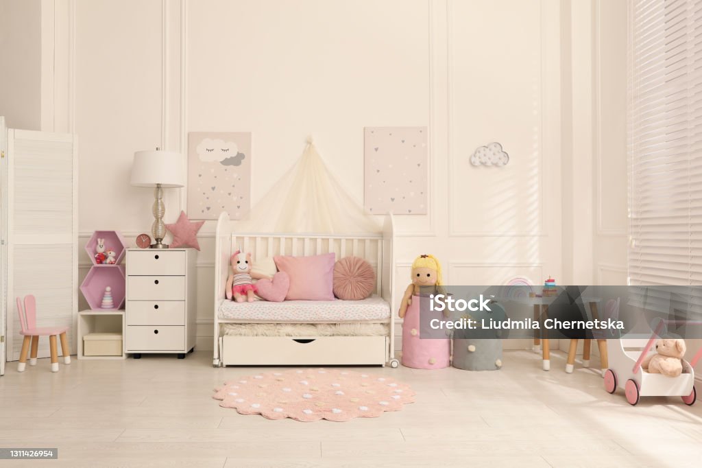 Cozy baby room interior with crib and toys Apartment Stock Photo
