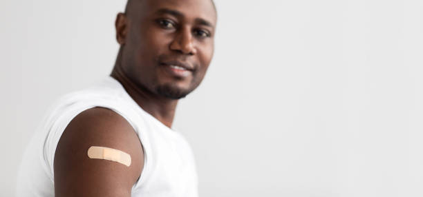 istock Coronavirus immunization. Positive black man showing his arm with an adhesive bandage panorama with free space 1311427939