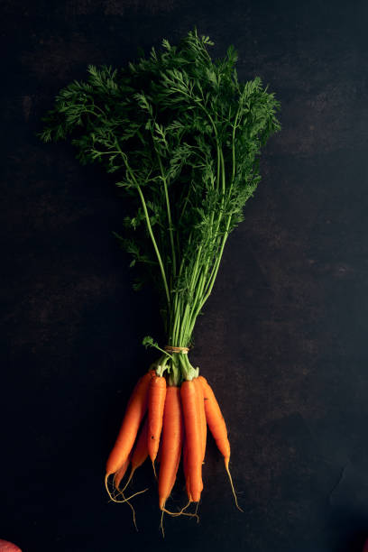 istock clean young carrots on a black background 1311428095