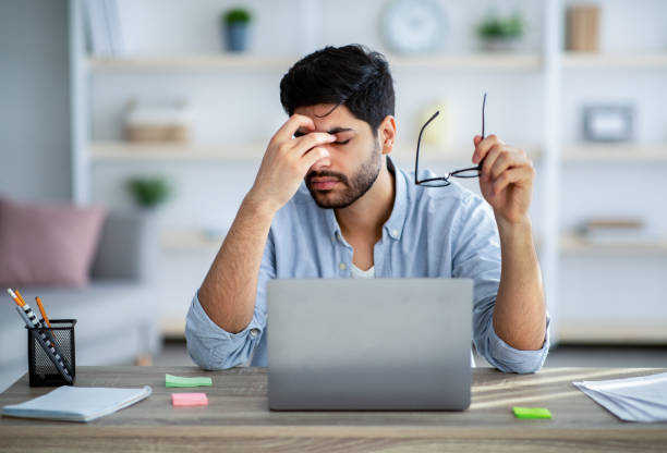 istock Overworked concept. Tired arab freelancer feeling exhausted while working on laptop and taking off glasses 1311428288