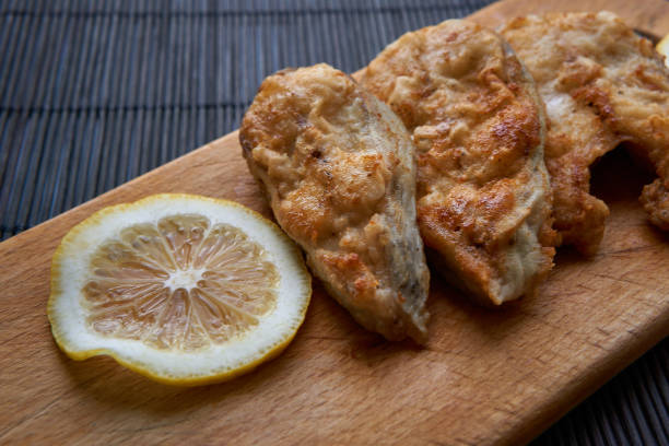 istock Pieces of fried fish with lemon wedges. 1311428367