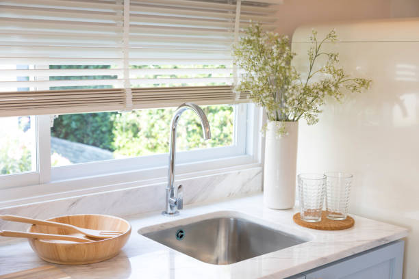 istock Clean new sink in stylish kitchen interior by the window. 1311428832