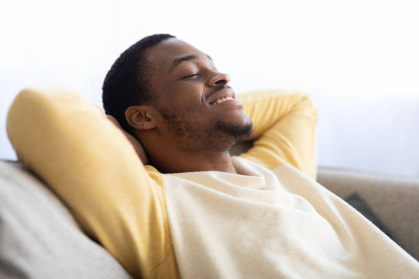 istock Closeup of black guy relaxing on couch at home 1311429426